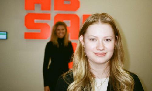 Studerende står ved logo